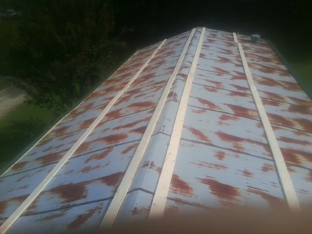 Rusted metal roof panels with new wood purlins before replacement — Storm Damage Roof Repair in Stovall by Roofing Brothers