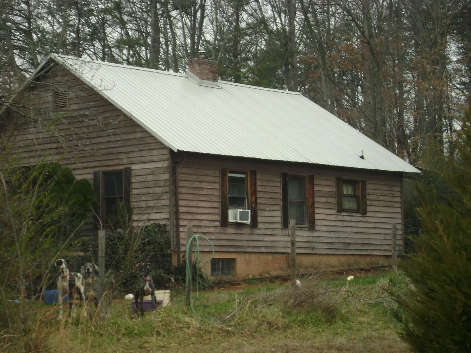 White metal roof on an old wood sided farmhouse, from a Metal Roof Installation job in Stovall